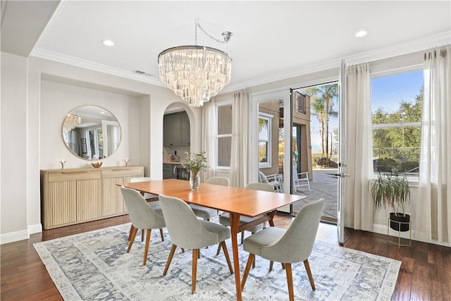 dining space with crown molding, a notable chandelier, wood finished floors, and baseboards