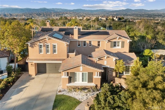 view of front of property with stucco siding, a mountain view, concrete driveway, and a garage