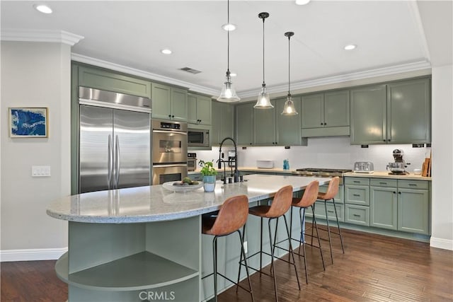 kitchen featuring green cabinets, crown molding, dark wood-type flooring, and built in appliances