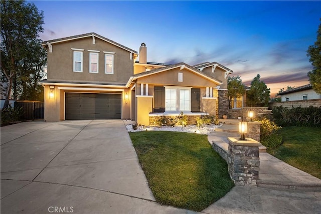 traditional-style house featuring stucco siding, concrete driveway, a front lawn, and fence