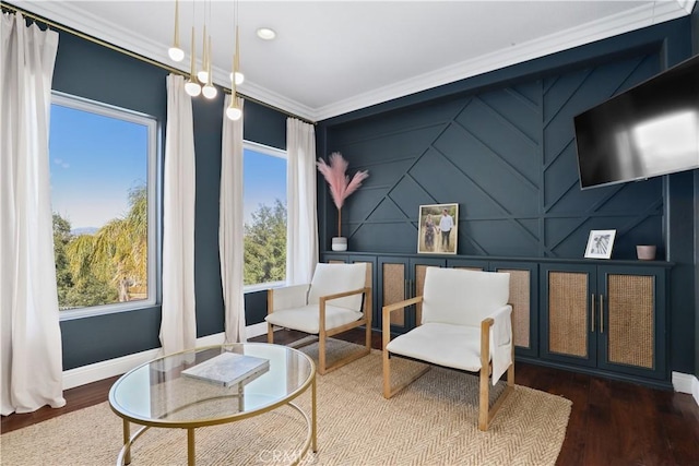 living area with baseboards, wood finished floors, and ornamental molding