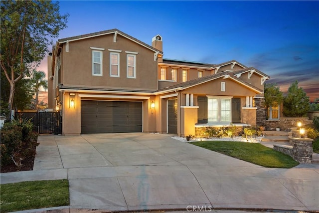 view of front of property with solar panels, an attached garage, fence, stucco siding, and driveway