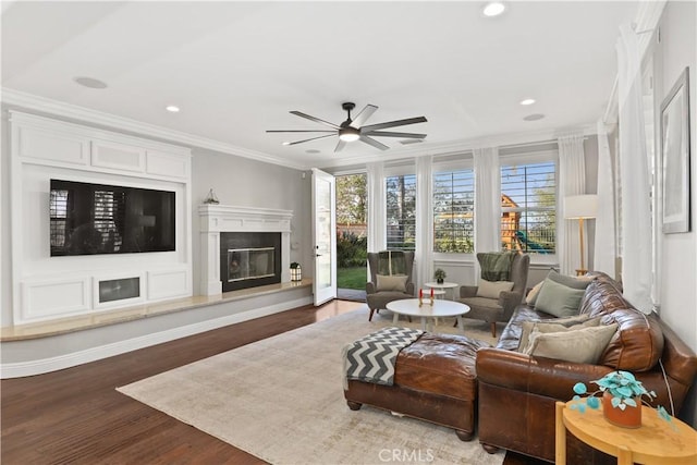 living room with ornamental molding, wood finished floors, a high end fireplace, recessed lighting, and ceiling fan