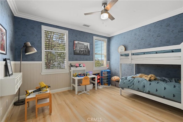 bedroom featuring wallpapered walls, wood finished floors, and a wainscoted wall