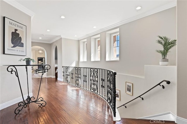 hall with recessed lighting, wood-type flooring, arched walkways, crown molding, and baseboards