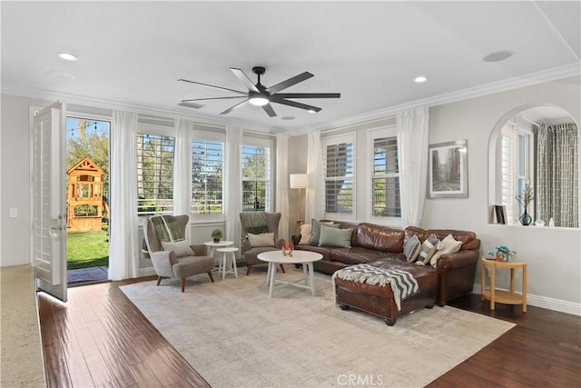 living room featuring ceiling fan, visible vents, ornamental molding, and dark wood finished floors