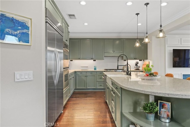 kitchen featuring visible vents, ornamental molding, open shelves, built in fridge, and green cabinets