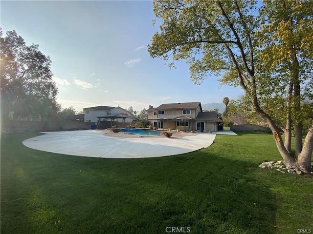 rear view of house with an outdoor pool, a yard, a gazebo, and a patio area