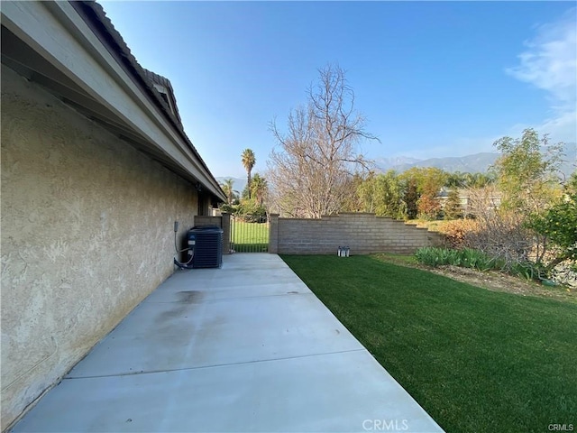 view of home's exterior featuring central air condition unit, stucco siding, a lawn, a patio, and fence