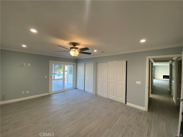 unfurnished bedroom with baseboards, recessed lighting, access to exterior, light wood-style floors, and crown molding