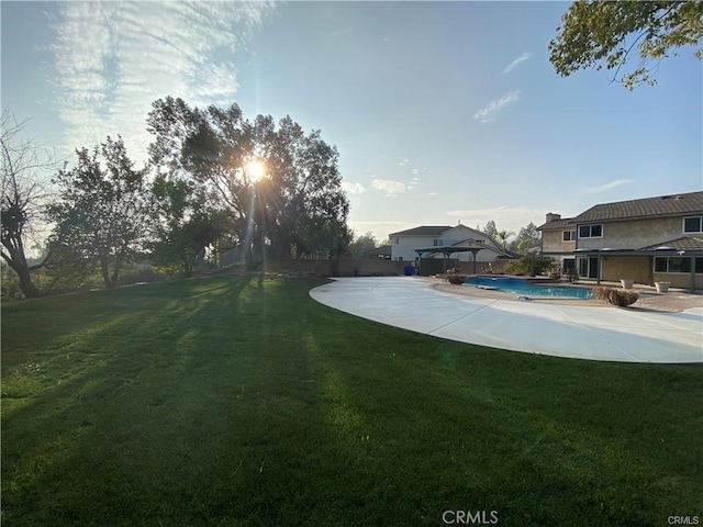 view of yard featuring a patio area, an outdoor pool, and fence