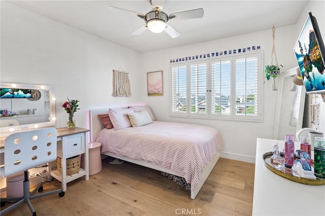 bedroom with baseboards, light wood finished floors, and ceiling fan