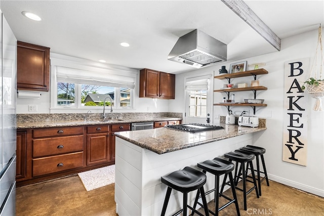 kitchen featuring a sink, open shelves, a kitchen breakfast bar, recessed lighting, and wall chimney exhaust hood