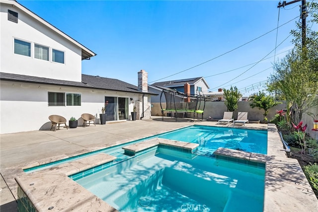 view of swimming pool featuring a patio area, a fenced backyard, and a pool with connected hot tub