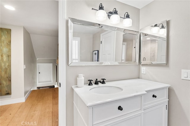 bathroom featuring vanity, baseboards, and wood finished floors