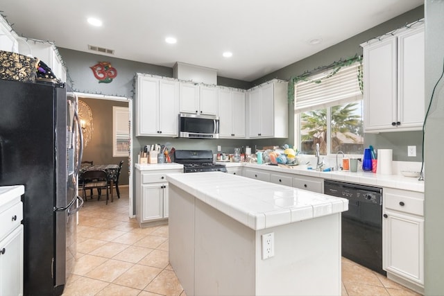 kitchen with stainless steel appliances, tile counters, light tile patterned flooring, and visible vents