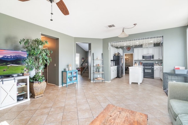 kitchen with light countertops, visible vents, a ceiling fan, open floor plan, and black appliances