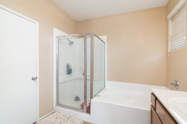 bathroom with a stall shower, a bath, and vanity