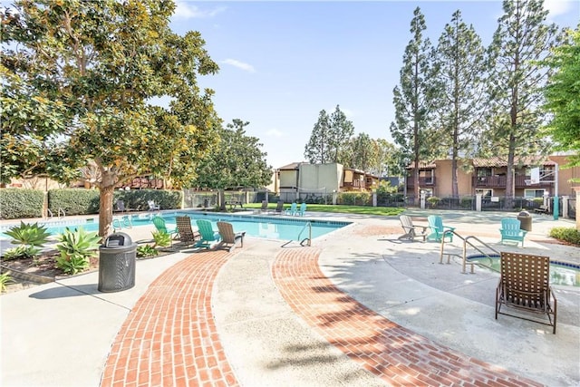 pool featuring fence and a patio