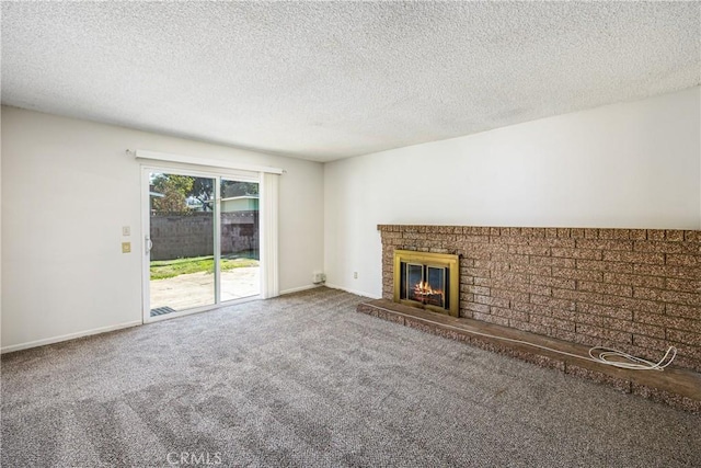 unfurnished living room with a textured ceiling, carpet, a fireplace, and baseboards