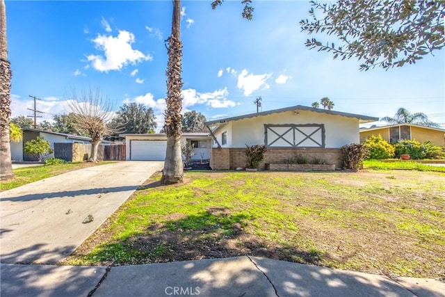 view of front of property with driveway, a front lawn, an attached garage, and stucco siding