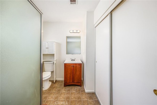 bathroom featuring baseboards, visible vents, vanity, and toilet