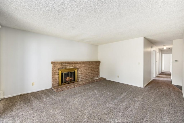 unfurnished living room with a textured ceiling, a fireplace, carpet flooring, and baseboards