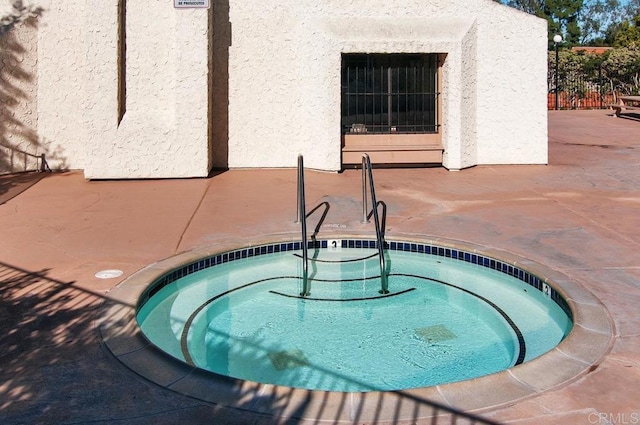 view of pool featuring a patio area and a hot tub