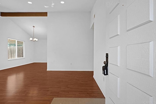 spare room with baseboards, lofted ceiling with beams, wood finished floors, an inviting chandelier, and recessed lighting