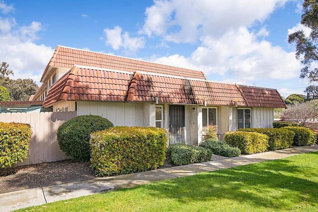 view of front of house featuring a tile roof and fence