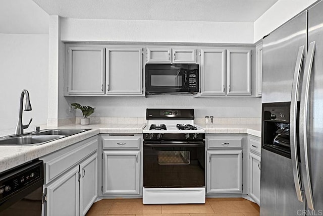 kitchen featuring a sink, black appliances, and light tile patterned floors