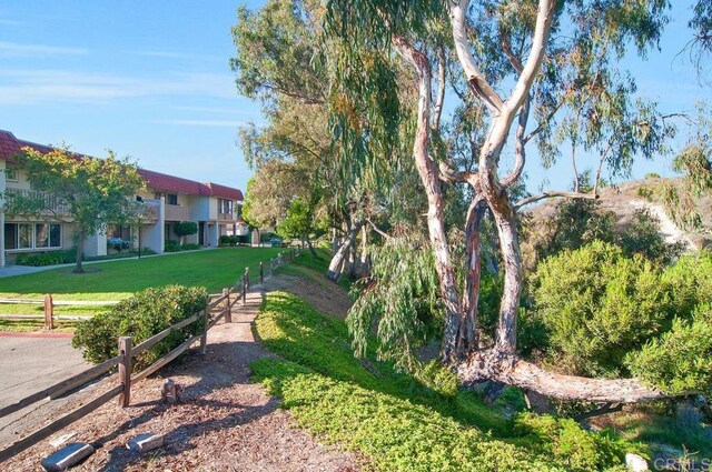 view of community featuring a yard and fence