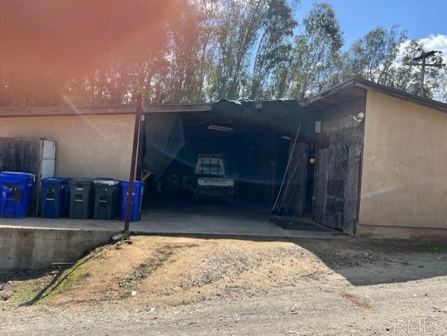 garage featuring driveway and an attached carport