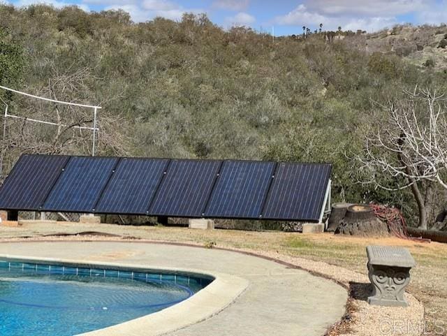 view of swimming pool with a view of trees