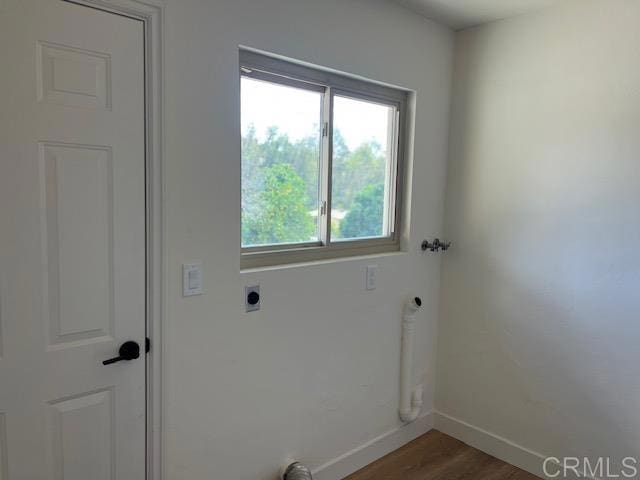 laundry area featuring laundry area, baseboards, wood finished floors, and hookup for an electric dryer