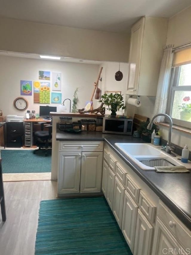 9946 Nutby Ln, Escondido, CA 92026 - kitchen with stainless steel microwave, a peninsula, a sink, a desk, and dark countertops