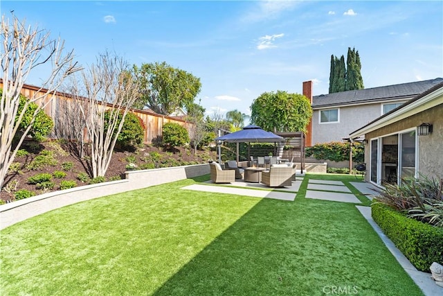 view of yard featuring a gazebo, an outdoor hangout area, a patio, and a fenced backyard