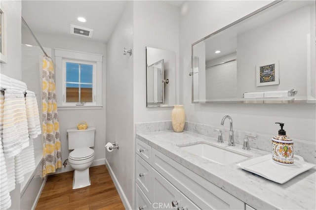 full bathroom featuring visible vents, toilet, wood finished floors, baseboards, and vanity