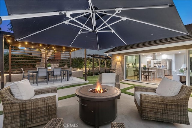 view of patio featuring outdoor dining space and an outdoor living space with a fire pit