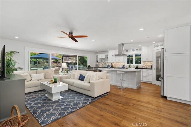 living room with plenty of natural light, light wood-style floors, and recessed lighting