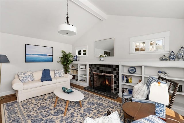 living area with a fireplace, lofted ceiling with beams, baseboards, and wood finished floors