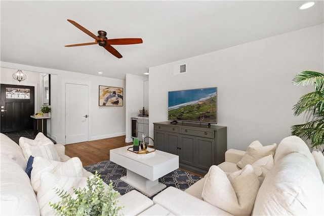 living area featuring visible vents, recessed lighting, dark wood-type flooring, and baseboards