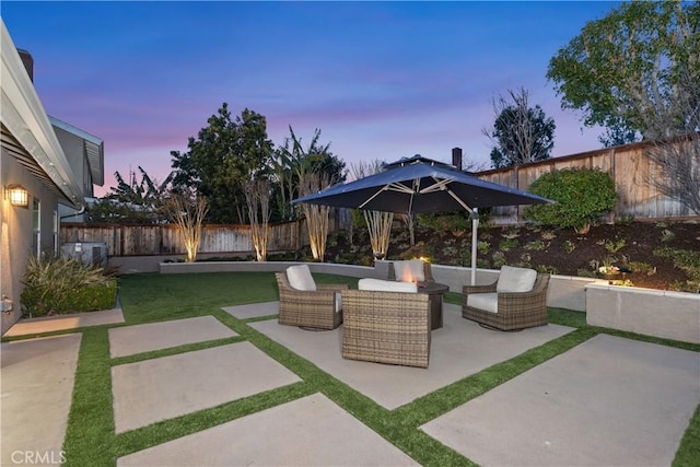 patio terrace at dusk with an outdoor living space and a fenced backyard