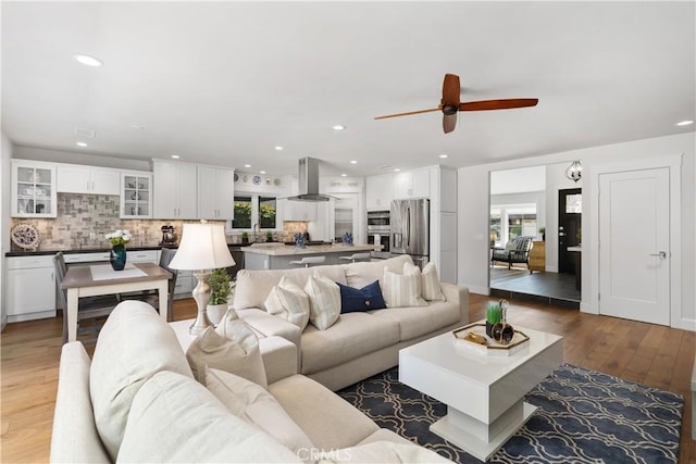 living area featuring a wealth of natural light, recessed lighting, and light wood finished floors