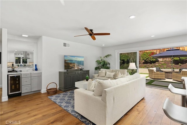 living room with beverage cooler, visible vents, light wood-style flooring, and recessed lighting