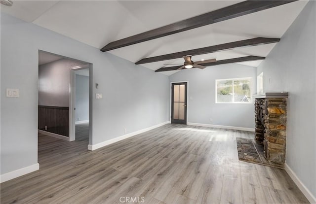 unfurnished living room with ceiling fan, lofted ceiling with beams, baseboards, and wood finished floors