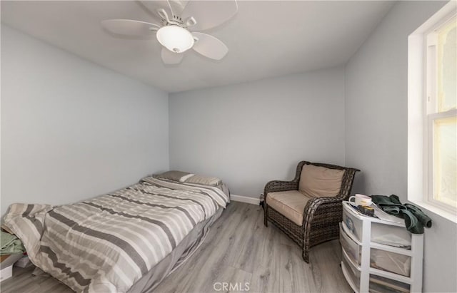 bedroom with ceiling fan, wood finished floors, and baseboards