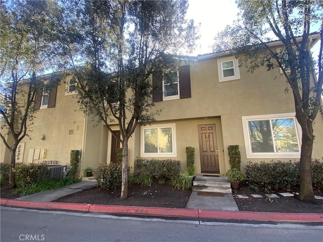 view of property featuring cooling unit and stucco siding