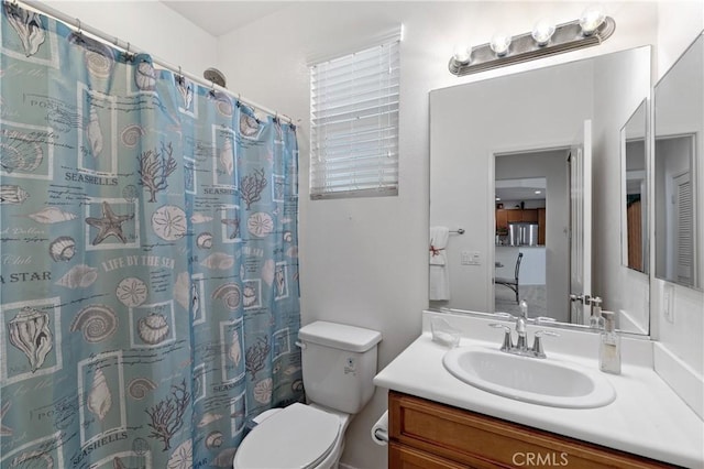 bathroom featuring toilet, vanity, and a shower with curtain