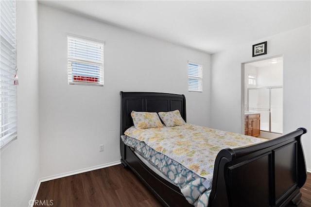 bedroom featuring baseboards, dark wood-style flooring, and connected bathroom